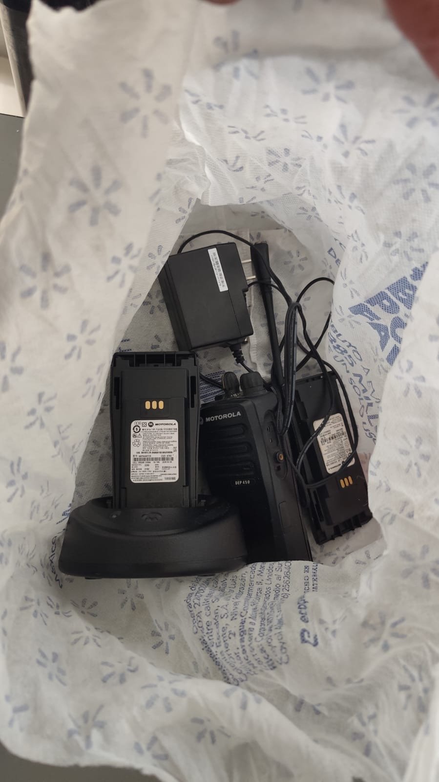 Radio Motorola, baterías y cargador guardados dentro de una bolsa